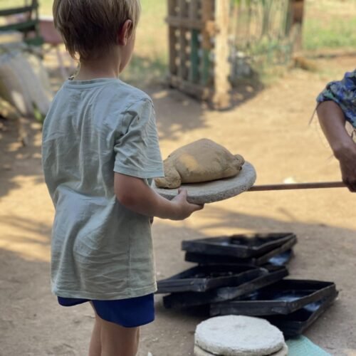 A child carrying a round of dough to the clay oven on a Luxor farm
