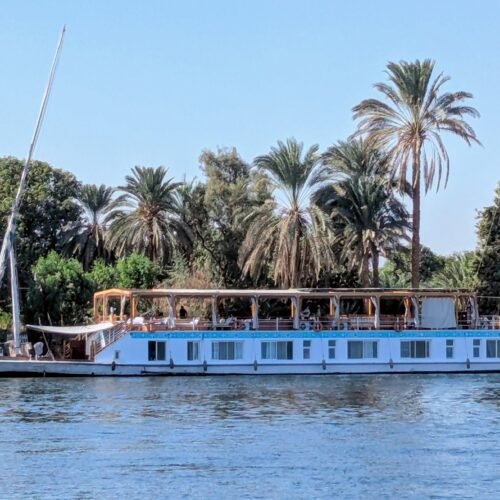 A dahabeya moored under date palms on the bank of the Nile