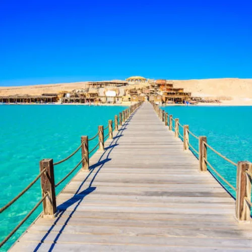 A wooden jetty running out over turquoise Red Sea water