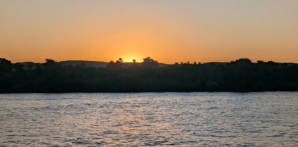Sunset over the Nile with palm trees