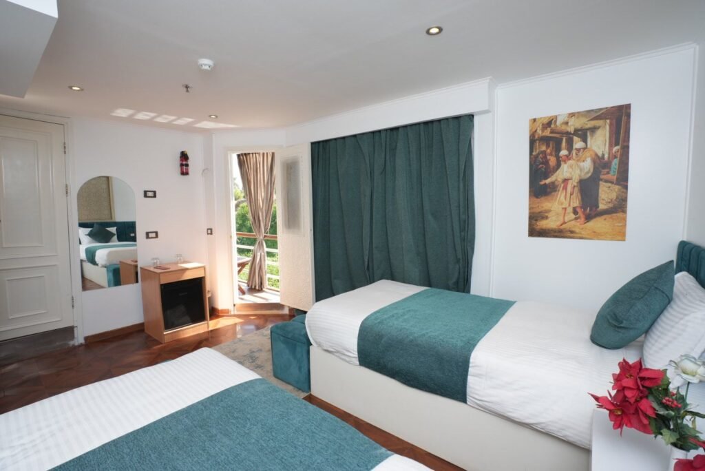 Double cabin on the dahabeya Konoz, the door standing open onto the wooden deck and the Nile